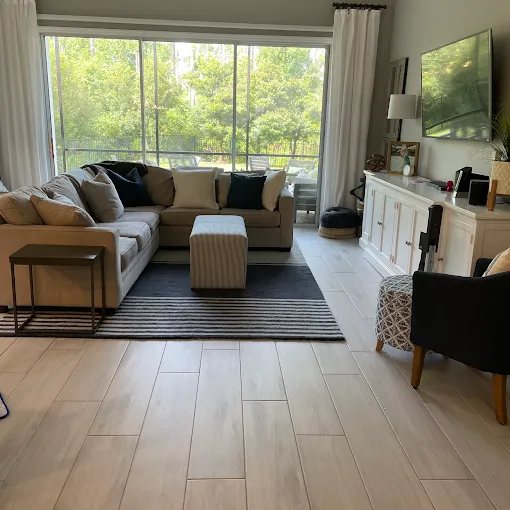 A clean living room with bright windows and hard-surface floors