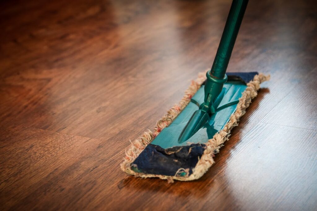 A person using a microfiber mop to clean hardwood floors gently
