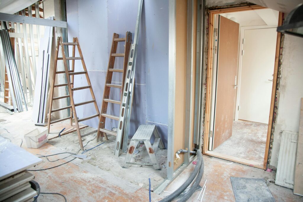 Interior view of a home in Mason, Ohio, undergoing post-construction cleanup with visible dust and construction materials around ladders and unfinished walls