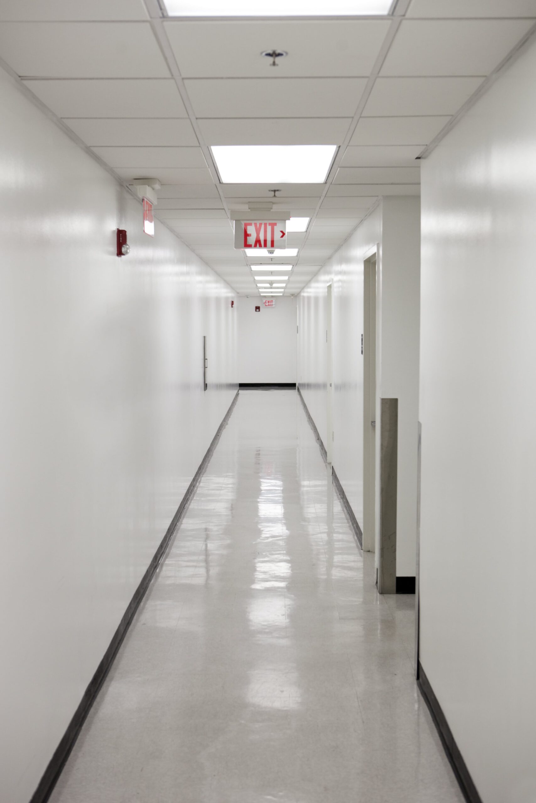 Long corridor with glistening VCT floors in Mason, OH after a professional strip and wax treatment.
