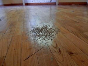 Deep scratches on a hardwood floor in Mason, Ohio, indicating the need for floor refinishing.